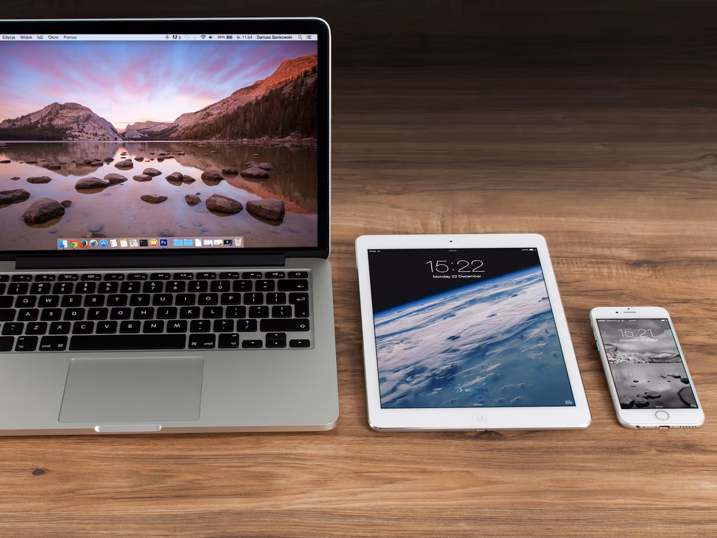 Notebook, Tablet und Smartphone nebeneinander auf einem Schreibtisch.