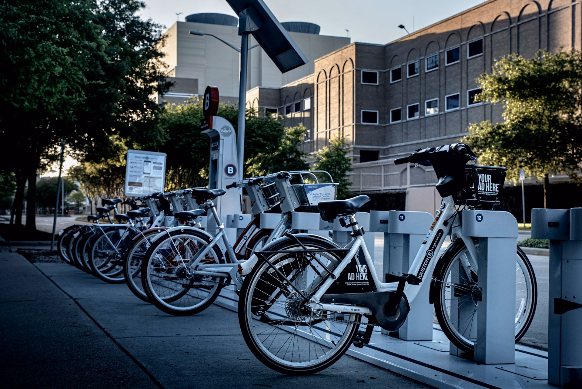 Abgestellte Fahrräder vor modernen Bürogebäuden.